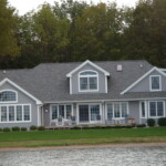 Perspectives Home Designs Gray 2-story home with a view of Glen Lake